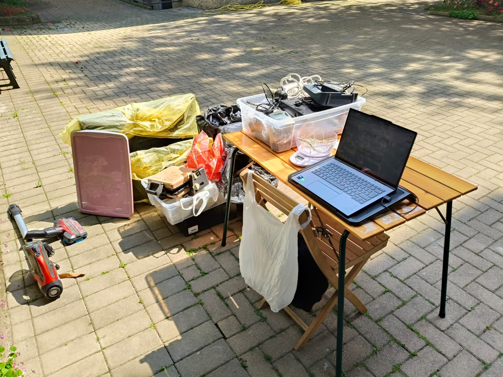 Tavolo operativo con laptop, bilancia e contenitori di RAEE conferiti