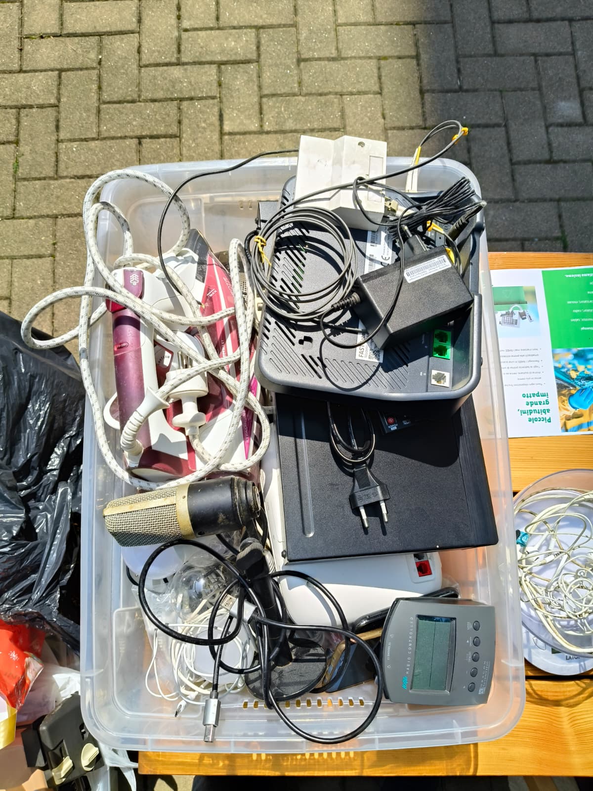 Contenitore con piccoli elettrodomestici, cavi, router e dispositivi elettronici
